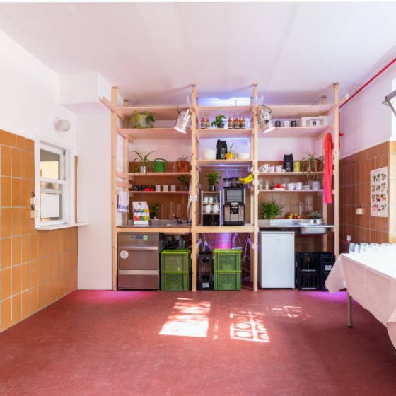 Raum mit Kühlschrank, Regal mit Geschirr und Spülmaschine